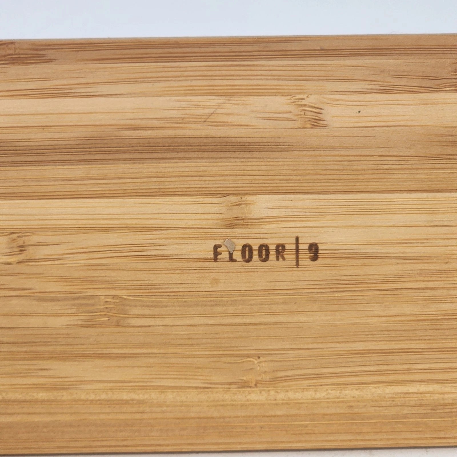 Wooden floor sample with 'FLOOR 9' branding on a light gray background